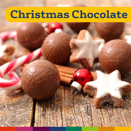 Chocolates natalinos variados, biscoitos em formato de estrela, bastões de doces e enfeites vermelhos em uma superfície de madeira com o texto "Chocolate de Natal de Manchester" no topo.