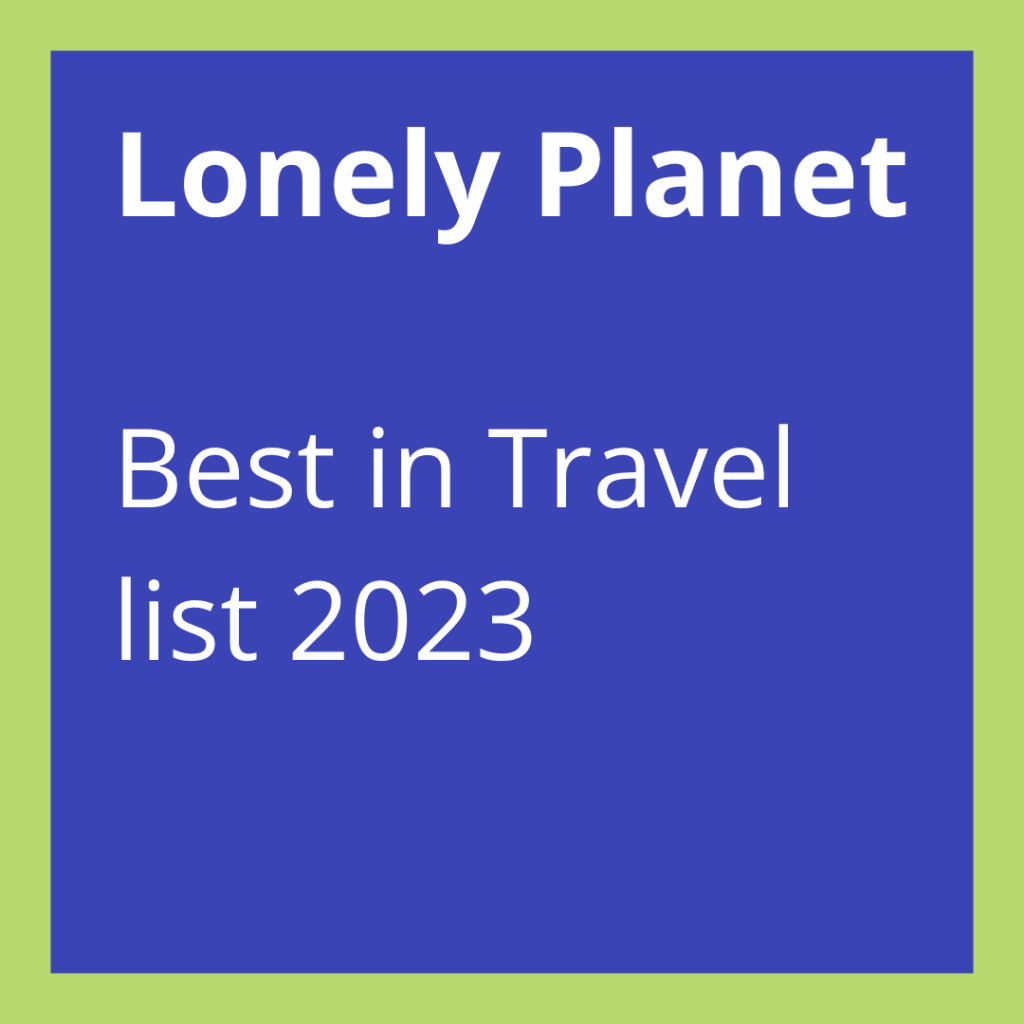A blue square with the text "Lonely Planet Best in Travel list 2023" on a green background celebrates Manchester as a top destination.